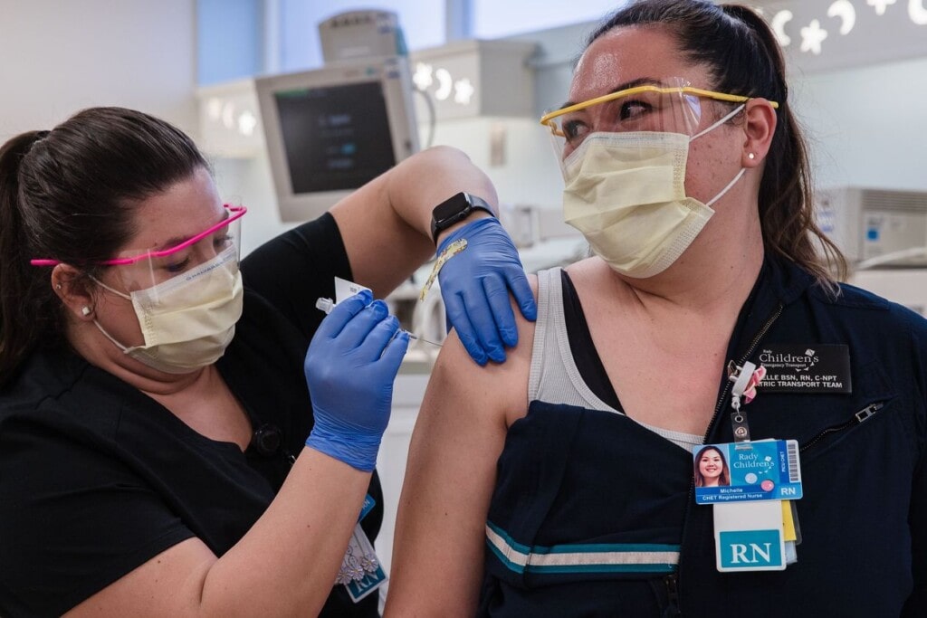 A nurse gets her vaccine shot