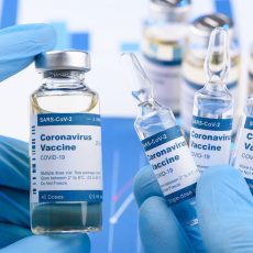 Closeup of vials of the COVID vaccine being held